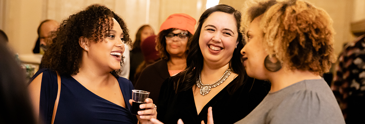 Female patrons enjoying a Community Welcome Reception a